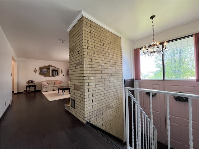 corridor featuring an upstairs landing, dark wood finished floors, and a chandelier
