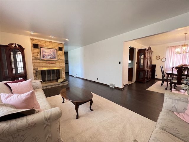 living room with a chandelier, dark wood-style floors, baseboards, and healthy amount of natural light