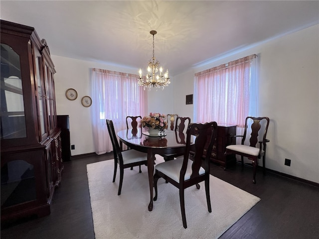 dining space with a chandelier, dark wood finished floors, and baseboards