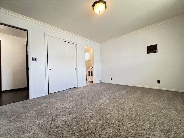 unfurnished bedroom with crown molding, carpet, baseboards, and a closet