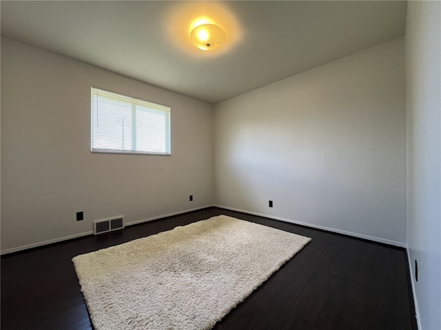 unfurnished room featuring dark wood-style floors and baseboards