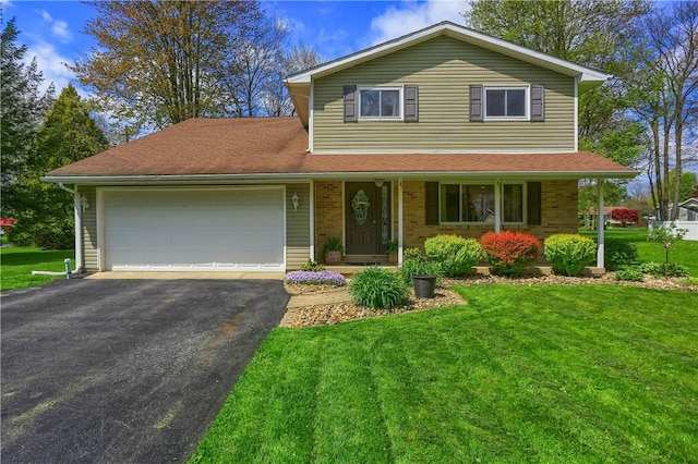 traditional-style home featuring an attached garage, asphalt driveway, a front yard, covered porch, and brick siding