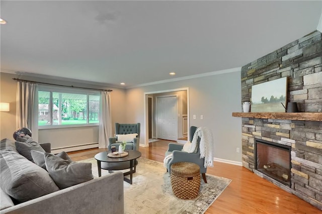 living room with a baseboard heating unit, crown molding, a stone fireplace, light wood-style floors, and baseboards