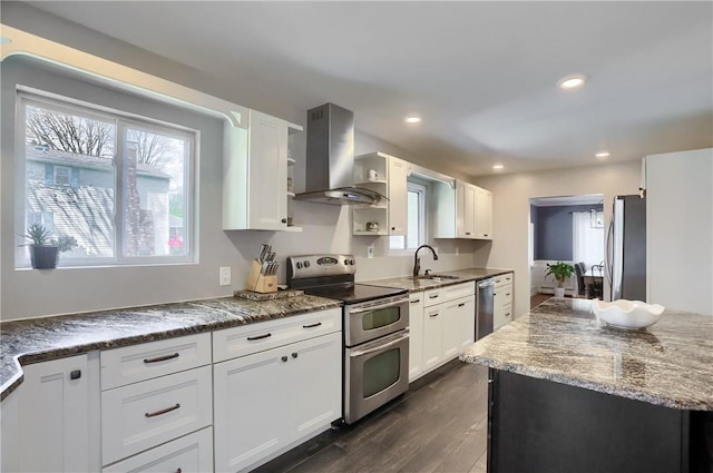 kitchen with wall chimney exhaust hood, stainless steel appliances, plenty of natural light, white cabinetry, and recessed lighting