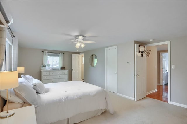 bedroom featuring baseboards, light carpet, and ceiling fan