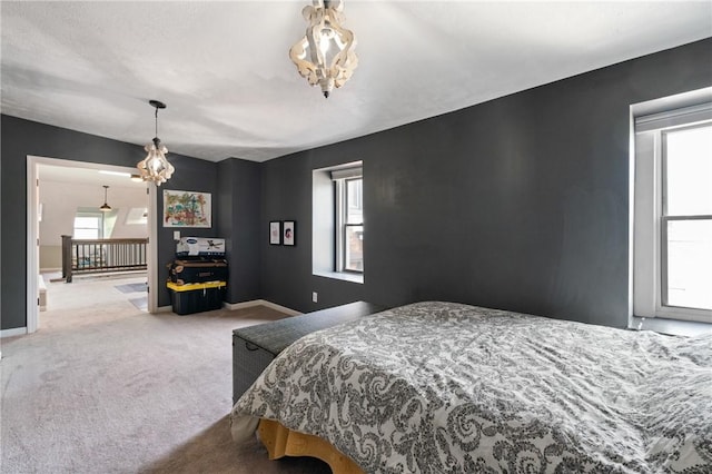 bedroom featuring a chandelier, carpet, and baseboards