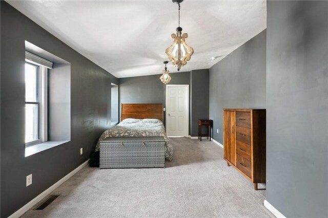 carpeted bedroom with a chandelier and baseboards