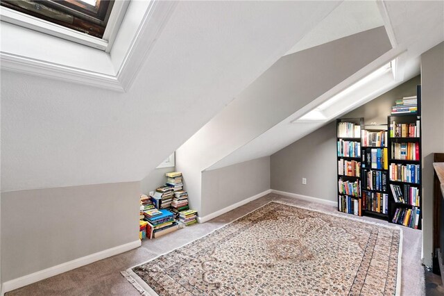recreation room with carpet floors, vaulted ceiling, and baseboards