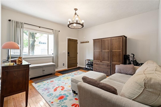 living area featuring a chandelier, wood finished floors, and baseboards