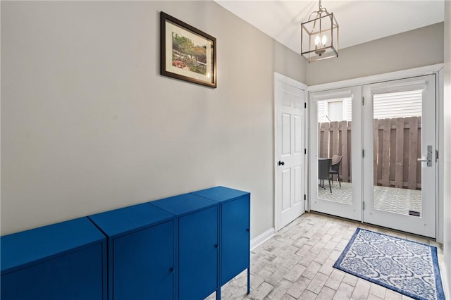 entryway featuring baseboards and a chandelier