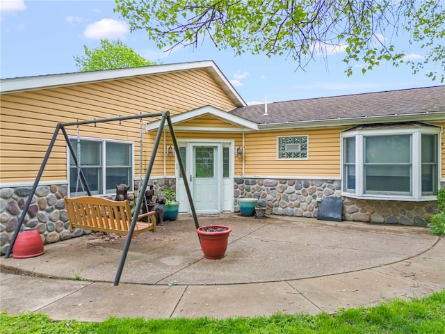 128 Evergreen Dr, Peters Twp, PA 15317 - back of property featuring stone siding, a patio, and a shingled roof