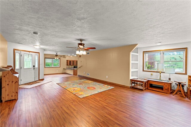128 Evergreen Dr, Peters Twp, PA 15317 - living area with wood finished floors, a textured ceiling, ceiling fan, and baseboards