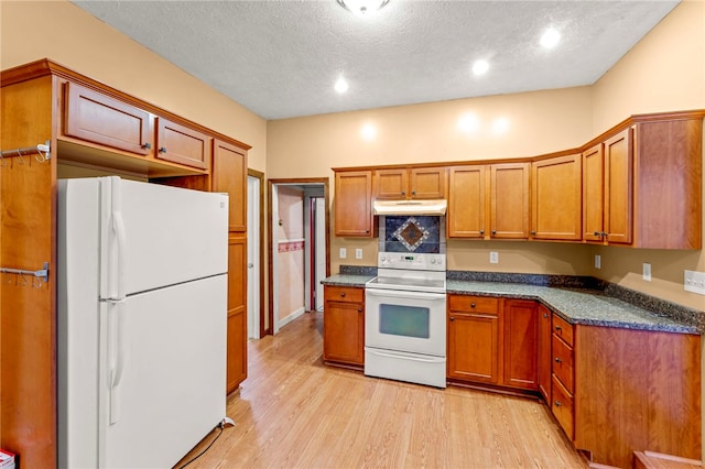 128 Evergreen Dr, Peters Twp, PA 15317 - kitchen with white appliances, under cabinet range hood, light wood-style floors, a textured ceiling, and brown cabinets
