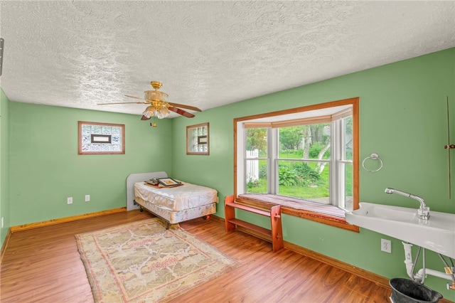 128 Evergreen Dr, Peters Twp, PA 15317 - bedroom with wood finished floors, baseboards, a textured ceiling, and ceiling fan