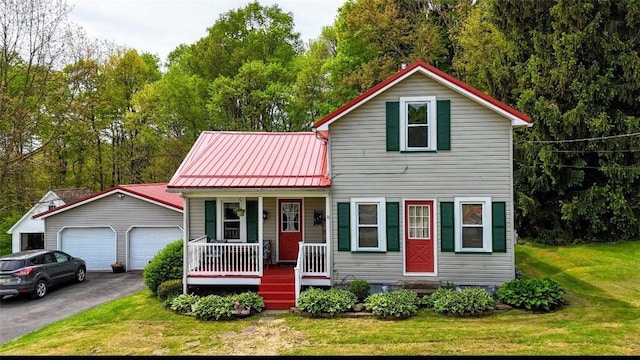 view of front facade featuring covered porch, a front lawn, a garage, and metal roof