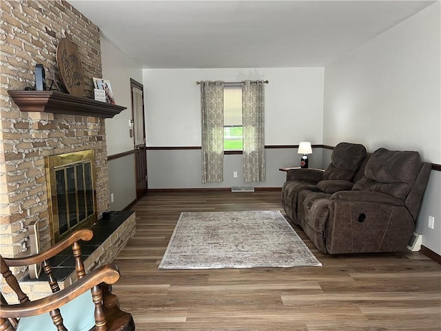 living room featuring wood finished floors, a fireplace, and baseboards
