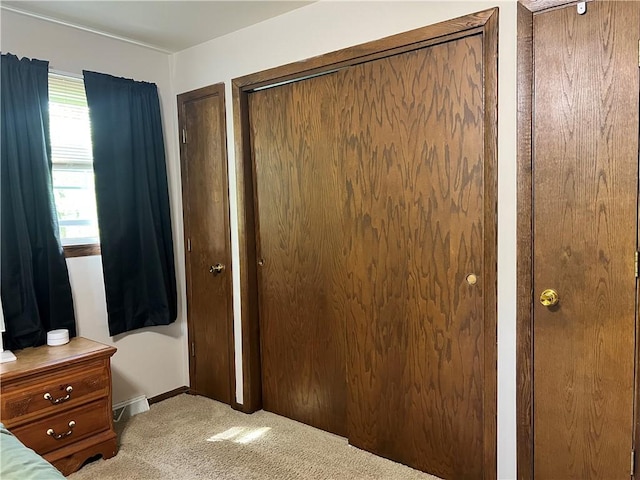 carpeted bedroom with two closets and baseboards