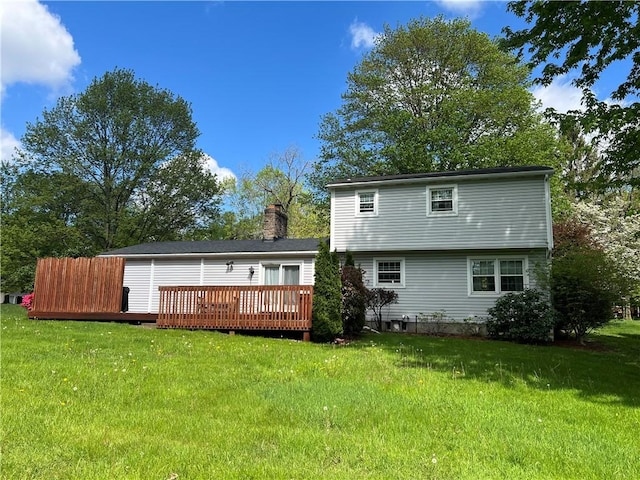 rear view of property with a deck and a lawn