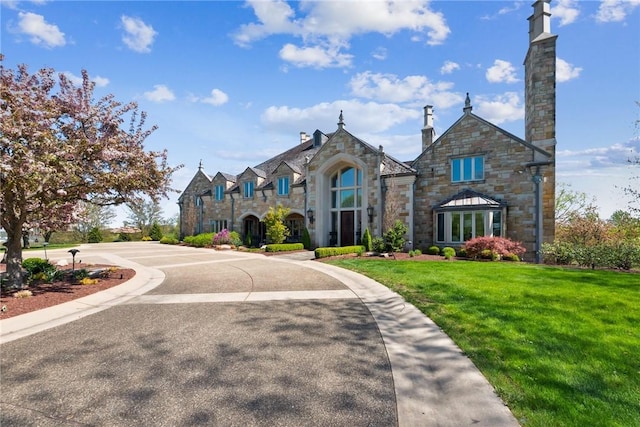 view of front of home with stone siding and a front yard