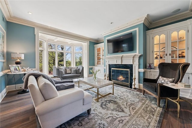 living area featuring ornamental molding, a fireplace, wood finished floors, baseboards, and recessed lighting