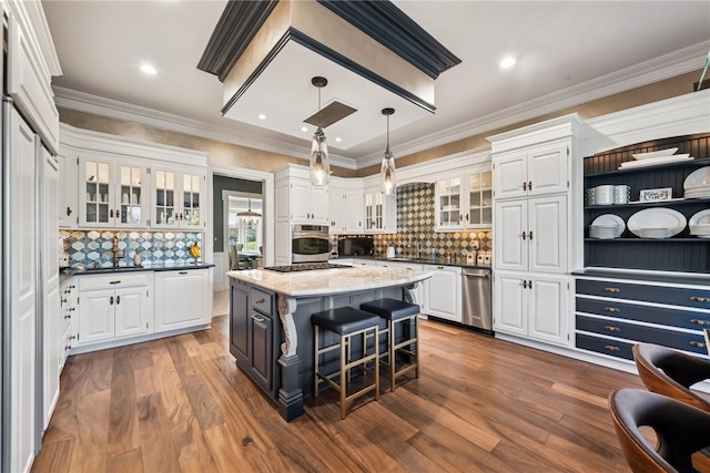 kitchen featuring stainless steel oven, white cabinets, tasteful backsplash, a kitchen island, and crown molding
