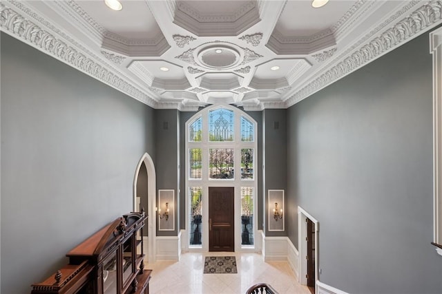 entrance foyer with a towering ceiling, coffered ceiling, crown molding, and recessed lighting