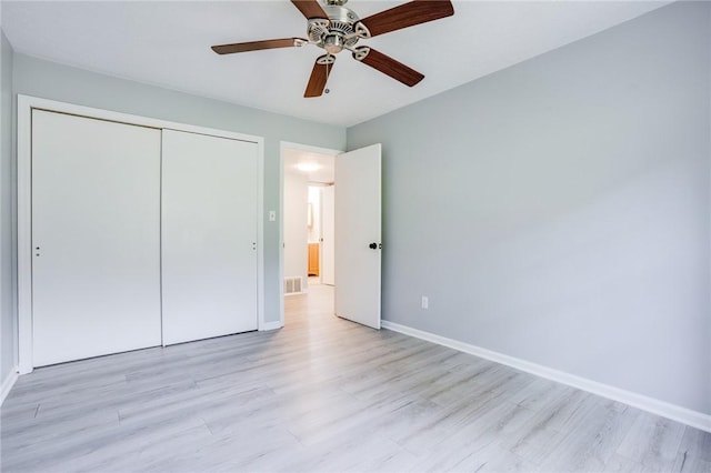 unfurnished bedroom featuring light wood finished floors, baseboards, a closet, and ceiling fan