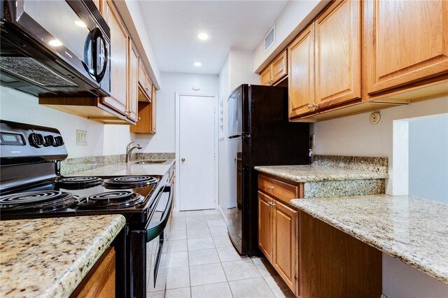 kitchen with black appliances, a sink, light tile patterned flooring, light stone countertops, and recessed lighting
