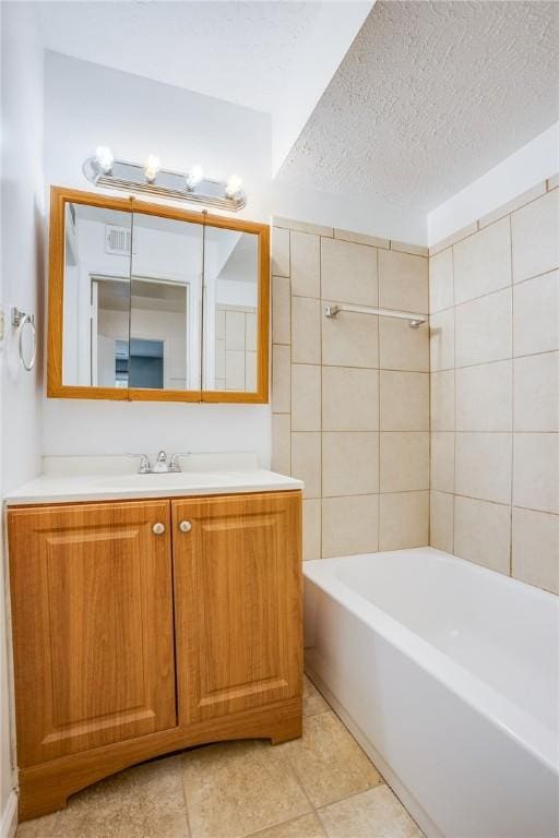 bathroom with tile patterned flooring, vanity, and a textured ceiling