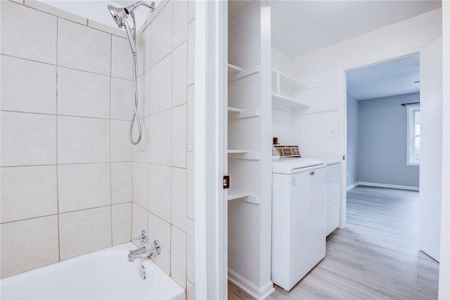 full bath featuring washer / dryer, wood finished floors,  shower combination, and baseboards