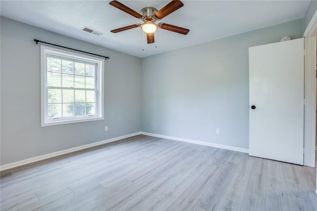 spare room with ceiling fan, light wood finished floors, and baseboards