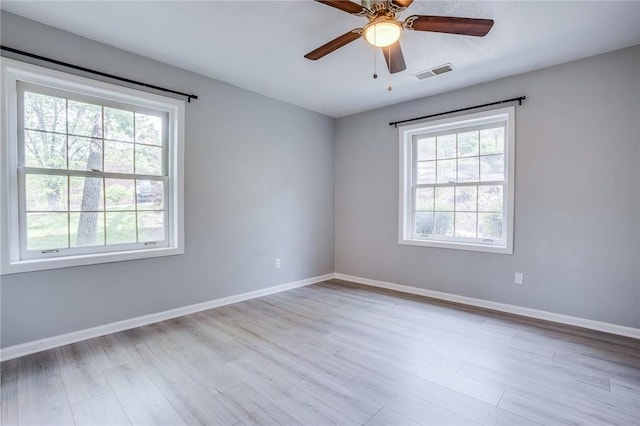 unfurnished room with baseboards, wood finished floors, and a ceiling fan