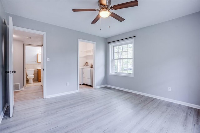 unfurnished bedroom with ensuite bathroom, separate washer and dryer, light wood finished floors, and baseboards