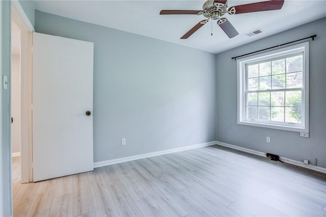 unfurnished room featuring a ceiling fan, light wood finished floors, and baseboards