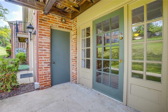 entrance to property featuring brick siding and french doors