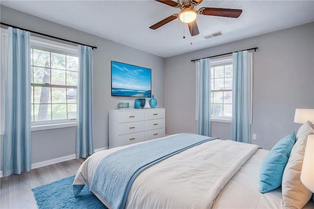 bedroom featuring light wood-style flooring, baseboards, and ceiling fan