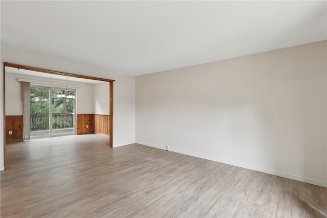 207 Parkwood Dr, Cranberry Twp, PA 16066 - empty room featuring wood finished floors, a chandelier, wainscoting, wood walls, and baseboards