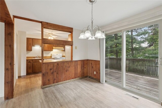 207 Parkwood Dr, Cranberry Twp, PA 16066 - unfurnished dining area featuring light wood finished floors, a wainscoted wall, a sink, a chandelier, and wood walls