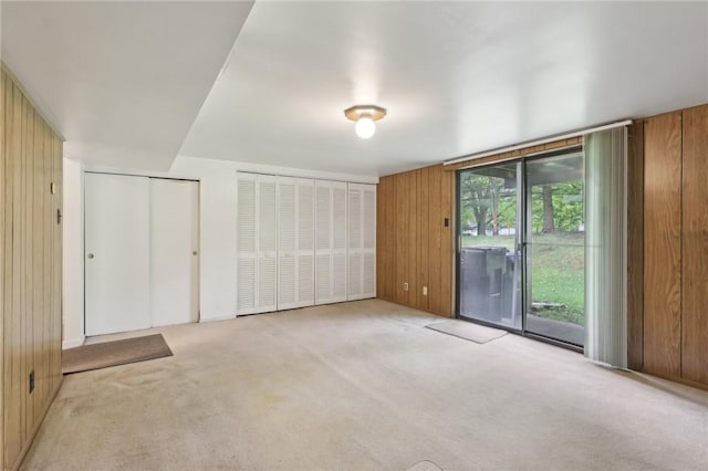 207 Parkwood Dr, Cranberry Twp, PA 16066 - unfurnished bedroom featuring access to outside, light carpet, wooden walls, and multiple closets