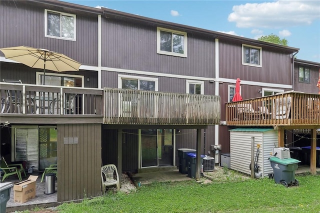 207 Parkwood Dr, Cranberry Twp, PA 16066 - rear view of house with a deck, a lawn, a storage shed, an outbuilding, and central air condition unit