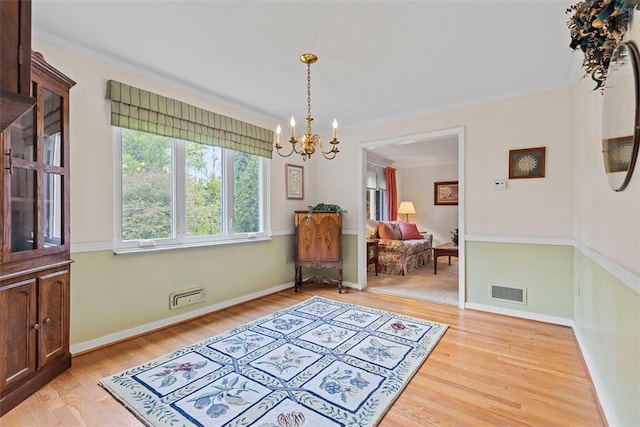 dining area featuring a chandelier, light wood finished floors, and baseboards