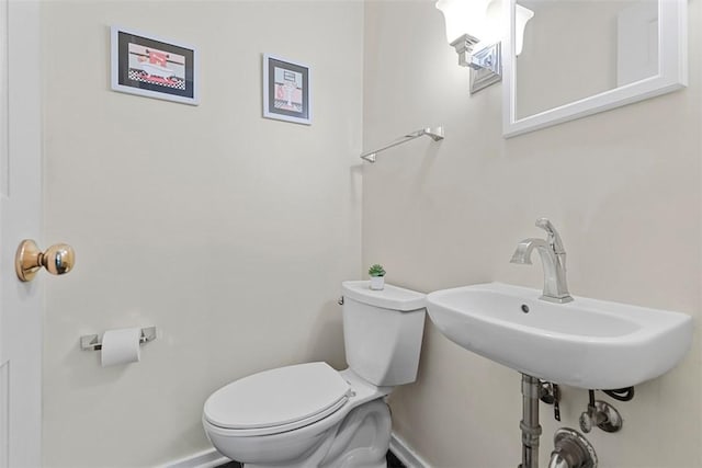 half bathroom with toilet and baseboards
