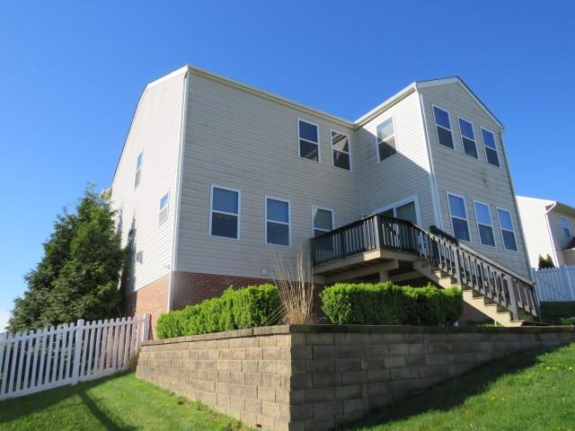 back of property featuring fence, stairs, and a wooden deck