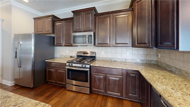 kitchen featuring stainless steel appliances, dark wood-style floors, crown molding, dark brown cabinetry, and baseboards