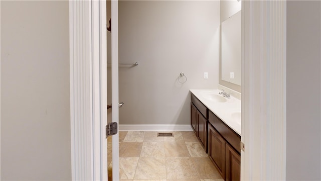 bathroom featuring double vanity and baseboards