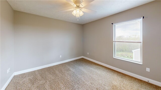 spare room featuring carpet floors, baseboards, and a ceiling fan