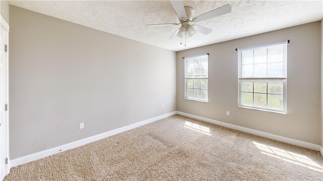 carpeted spare room with baseboards, a textured ceiling, and ceiling fan