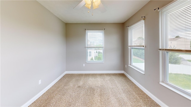 carpeted empty room with healthy amount of natural light, baseboards, and ceiling fan