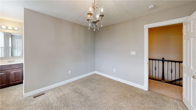 empty room featuring light colored carpet, a chandelier, a smoke detector, and baseboards