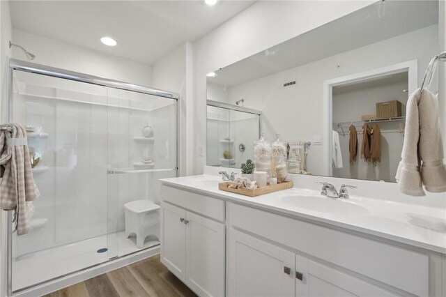 122 River Ridge Drive, Moon/Crescent Twp, PA 15108 - bathroom featuring a shower stall, wood finished floors, double vanity, recessed lighting, and a walk in closet